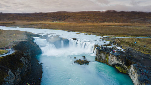 Scenic view of waterfall against sky