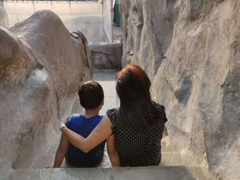 Rear view of people walking on rock