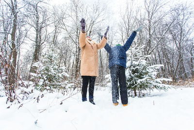 Rear view of woman standing on snow covered land