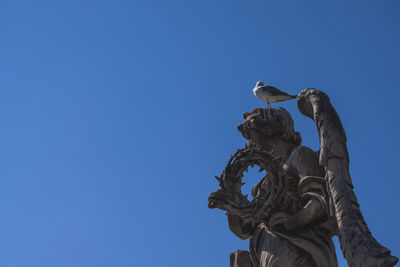 Low angle view of statue against clear blue sky