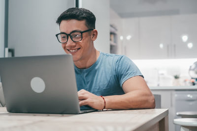 Portrait of man using laptop at table