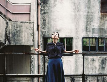 Portrait of young man standing by railing