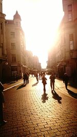 People walking on street amidst buildings in city