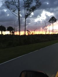 Road passing through landscape against cloudy sky