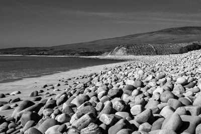 Surface level of stones on beach against sky