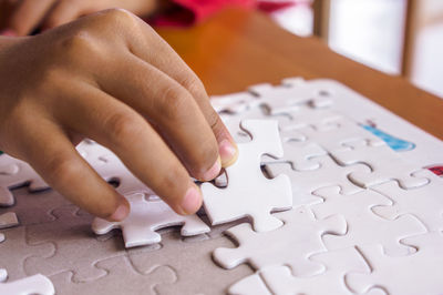 Close-up of hands playing jigsaw puzzle