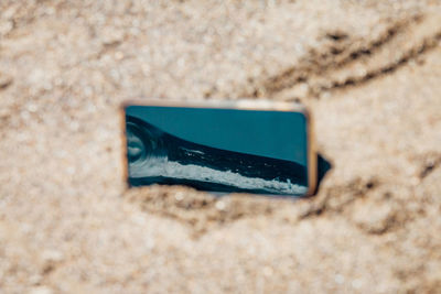 Directly above view of smart phone at beach