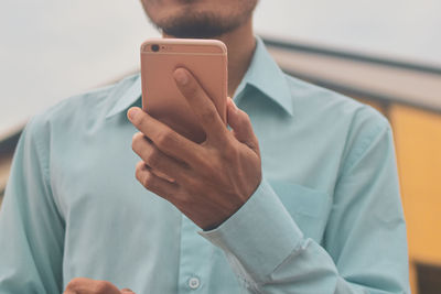 Midsection of man using mobile phone