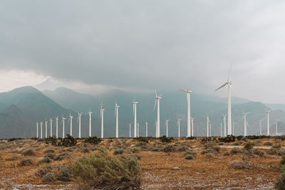 Wind turbines on land against sky