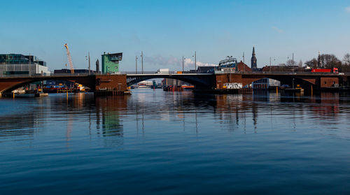 Bridge over river in city against sky