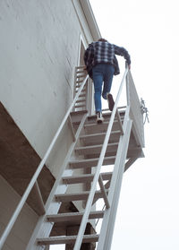 Low angle view of man on staircase against wall