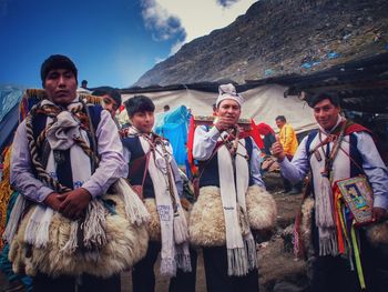 People standing on mountain against the sky