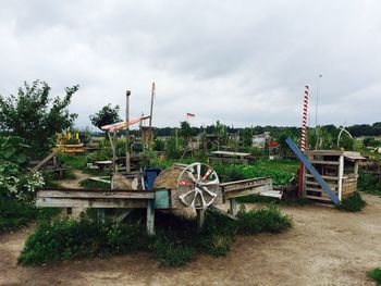 Chairs and table against trees against sky
