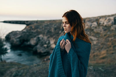 Mid adult woman looking at sea shore against sky