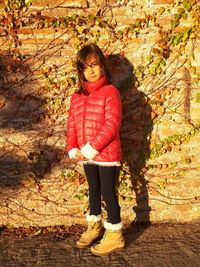 Full length portrait of girl standing against tree during autumn