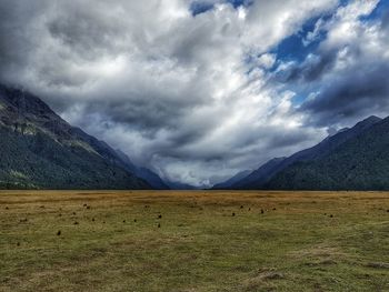 Scenic view of landscape against storm clouds