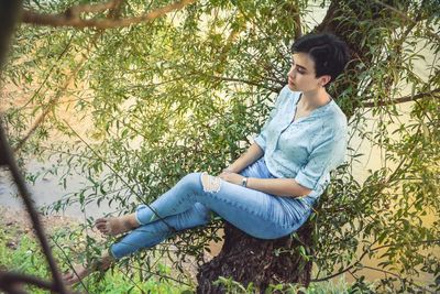 High angle view of woman sitting on branch