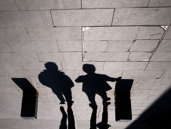 Silhouette men standing against wall