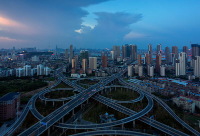 High angle view of elevated road by buildings in city against cloudy sky at dusk