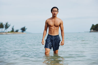 Shirtless man swimming in sea