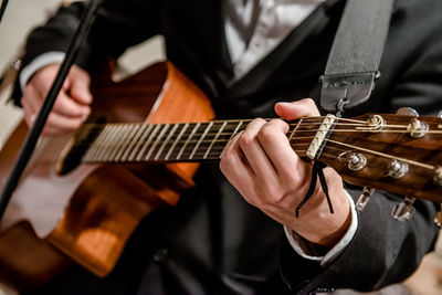 Midsection of musician playing guitar