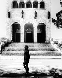 Rear view of woman walking on staircase of building