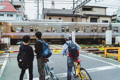 Rear view of people riding motorcycle on road