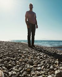 Full length of man standing at beach against clear sky