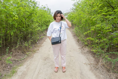 Full length of woman standing on road