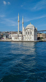 View of buildings at waterfront against blue sky