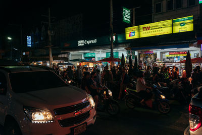 Panoramic view of people on street in city at night