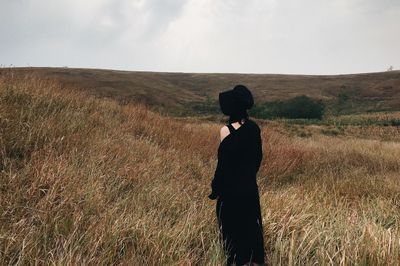 Woman standing on field against sky