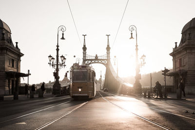 Tram on street against liberty bridge