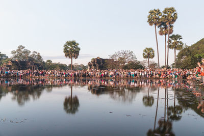 Group of people by swimming pool against clear sky