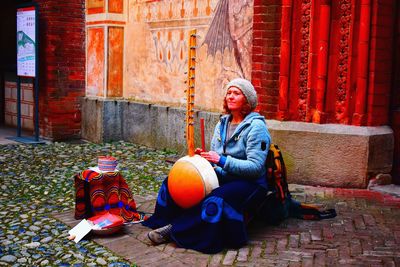 Rear view of woman sitting on street