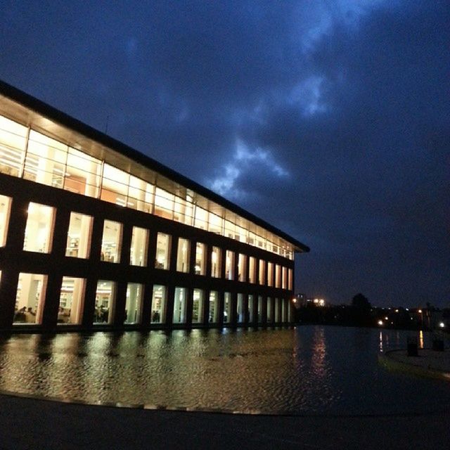 architecture, built structure, sky, building exterior, illuminated, night, cloud - sky, reflection, water, dusk, city, cloudy, cloud, building, no people, low angle view, outdoors, modern, street light, lighting equipment