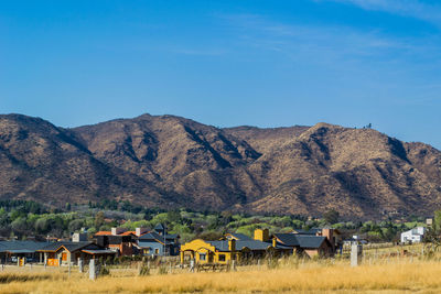 Houses and mountains against blue sky