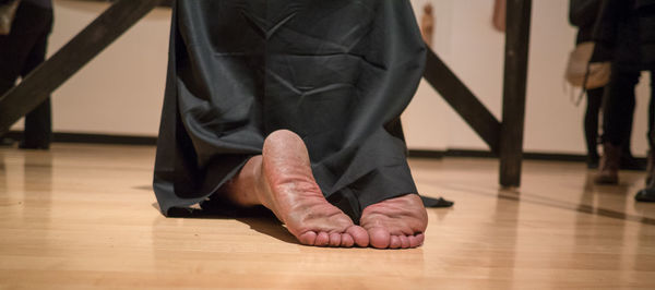 Low section of man sitting on hardwood floor