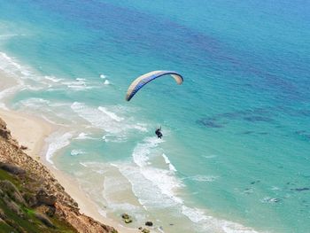 High angle view of person paragliding over sea