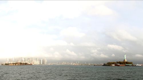 Panoramic view of sea and cityscape against sky