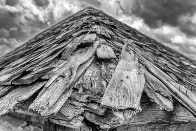 Low angle view of wooden structure against cloudy sky