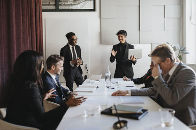 Business colleagues discussing with each other during meeting in board room at office