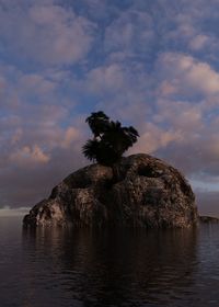 Rock formation in sea against sky