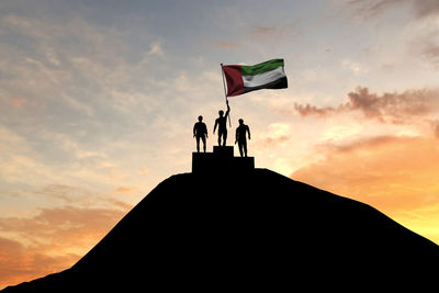 Low angle view of silhouette people standing against sky during sunset