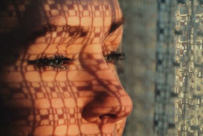 Close-up of woman looking away with shadow on face