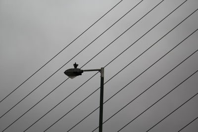 Low angle view of power lines against sky