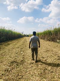 Rear view of man walking on field