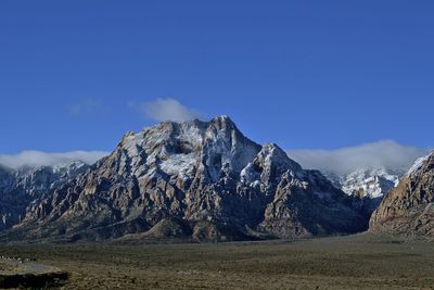 Scenic view of snowcapped mountains against blue sky