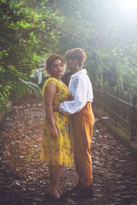 Full length view of a couple hugging in a garden. 