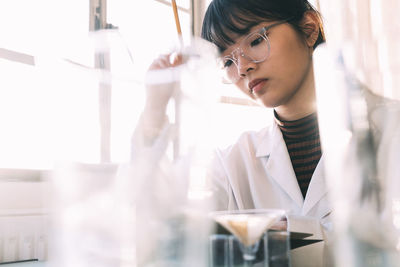 Young chemist working with concentration in laboratory